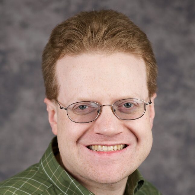 A headshot of Dudley Lemming PhD, wearing a green shirt with a grey background.