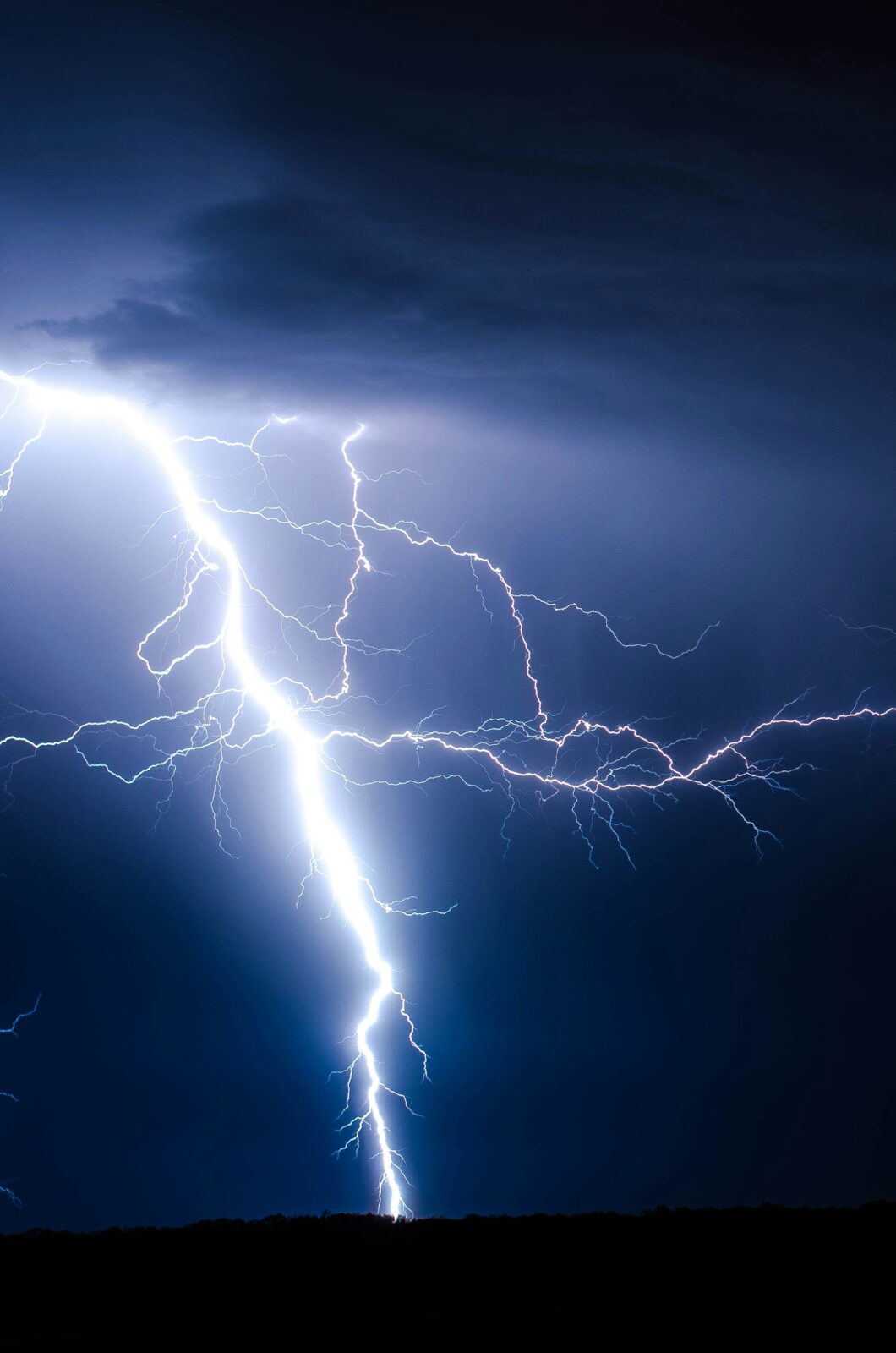 A blue lightning strike against the sky